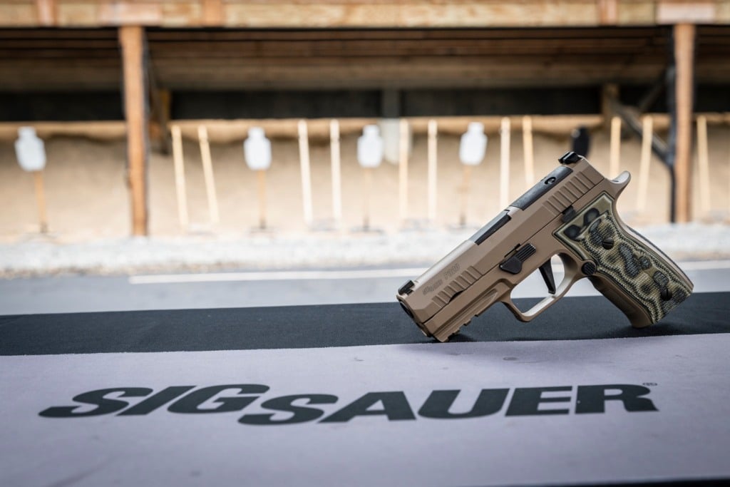 Pistola da Sig Sauer, P320, apoiada numa bancada Pistola da Sig Sauer, P320, apoiada numa bancada