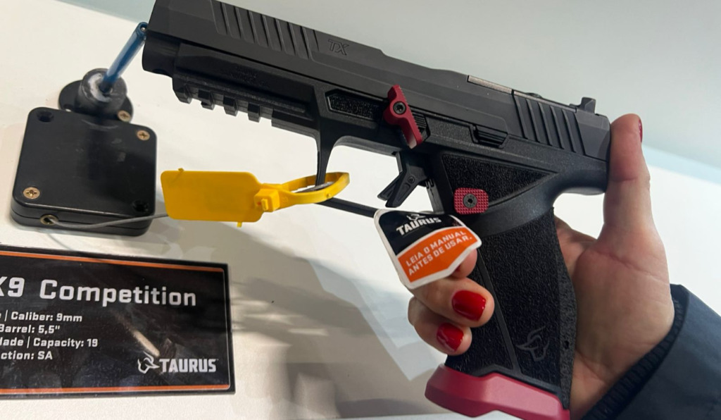 Mão segura uma pistola Taurus TX9 Competition, versão cano longo